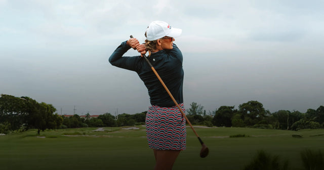 Woman practicing golf swing.