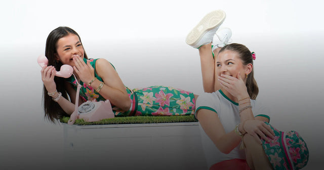 Two girls wearing golf outfits and playing.