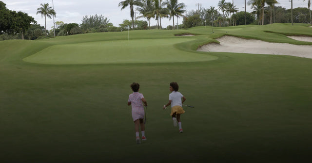 Two girls running in a golf course and dressed with stylish golf clothes by Marie Birdie.